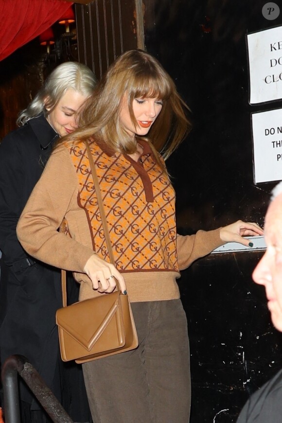 Taylor Swift adopte le style androgyne de l'automne en sortant d'un dîner au Minetta Tavern. Elle porte un pull à motifs et un pantalon marron, avec des chaussures en cuir marron pour compléter son look, tandis que les caméras filment chacun de ses mouvements.