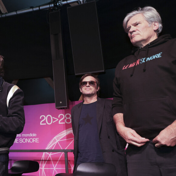 "Notre rapport au monde passe aussi par le son ! Ce dôme est destiné à voyager et a été conçu comme tel" selon ses propos rapportés par Ouest France
Exclusif - Jean-Michel Jarre, Thomas Dutronc, Stéphane Le Foll - Le compositeur Jean-Michel Jarre, parrain de la biennale du son "Le Mans sonore" a inauguré le Dôme sonore, à guichets fermés sur la place des Jacobins avec Thomas Dutronc et Stéphane Le Foll et a présenté sa dernière création, " Oxymore " au Mans le samedi 20 janvier 2024. " Heureux et honoré ", l'artiste s'est confié, quelques minutes avant l'événement, revenant sur l'importance de ce dôme " immersif ". " Pendant des siècles, notre rapport à la musique a été frontal ", a-t-il rappelé. ' " On a un rapport 2D avec la musique, ce qui est assez paradoxal puisque notre rapport au son dans le quotidien, c'est un rapport immersif, à 360 degrés. " Cette structure en bois, montée en une semaine, sur la place des Jacobins, au Mans permet une immersion sonore exceptionnelle. Dans la demi-sphère d'une hauteur de 9 mètres et d'un diamètre de 20 mètres qui peut accueillir jusqu'à 600 personnes debout, se dérouleront jusqu'au 28 janvier des concerts (de Meule et de Molécule) ainsi que du cinéma sonore de Radio France. © Jack Tribeca / Bestimage 