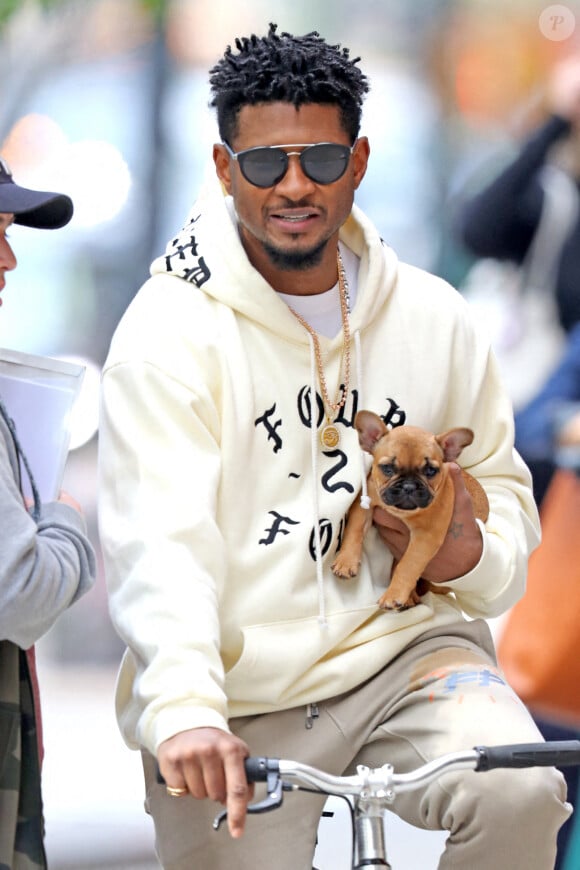 Usher fait du vélo en tenant son chien, NYC le 2 mai 2019. Photo by Splash News/ABACAPRESS.COM