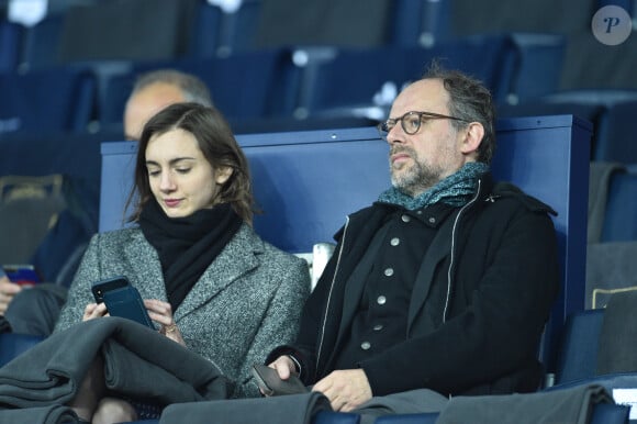 Les amoureux partagent l'amour du théâtre et de la comédie 
Denis Podalydès et sa compagne Leslie Menu dans les tribunes lors du match de quart de finale de la Coupe de Ligue opposant le Paris Saint-Germain à l'AS Saint-Etienne au Parc des Princes à Paris, France, le 8 janvier 2020. le PSG a gagné 6-1. © Giancarlo Gorassini/Bestimage 