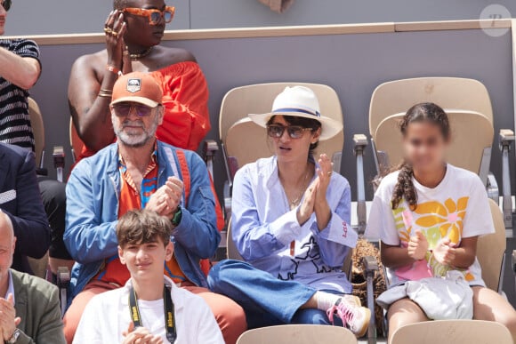 Ils étaient venus avec leur fille Selma. 
Eric Cantona et sa femme Rachida Brakni et leur fille Selma - Célébrités dans les tribunes de la finale Dames des Internationaux de Tennis de Roland Garros à Paris le 8 juin 2024. © Jacovides-Moreau/Bestimage 