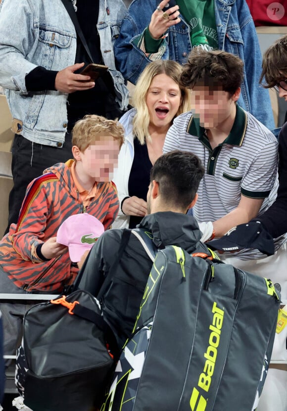 Parents de trois enfants (Roman né en 2008, Aliocha né en 2013 et un troisième enfant né au printemps 2024), le couple - qui s'est rencontré dans les loges d'un théâtre après un concert - semble s'aimer comme au premier jour.
Roman et Aliocha Haroche voient Carlos Alcaraz dédicacer leurs casquettes sous le regard de leurs parents, Mélanie Thierry et son compagnon Raphaël - Les célébrités dans les tribunes des Internationaux de France de tennis de Roland Garros 2024 à Paris, le 29 mai 2024. © Jacovides / Moreau / Bestimage 