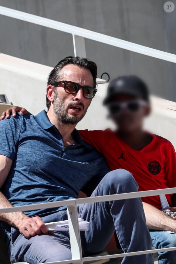 Avec son ex-compagnon Michaël Cohen, la mère de famille a également adopté en 2010 un petit garçon prénommé Surifel qui a à ce jour 15 ans.
Michaël Cohen et son fils Surifel dans les tribunes lors des internationaux de tennis de Roland Garros à Paris, France, le 1er juin 2019. © Jacovides-Moreau/Bestimage 