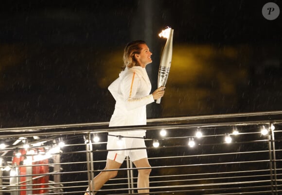 L'ancienne joueuse de tennis Amélie Mauresmo court avec la torche olympique à la main lors de la cérémonie d'ouverture des Jeux olympiques de Paris 2024 à Paris, en France, le 26 juillet 2024. Photo by Xinhua/Fei Maohua/ABACAPRESS.COM