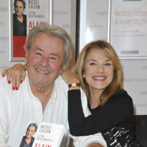 Alain Delon dedicace le livre "Lettre entr'ouverte a Alain Delon" de Nicole Calfan au Drugstore Publicis a Paris. Le 30 octobre 2012