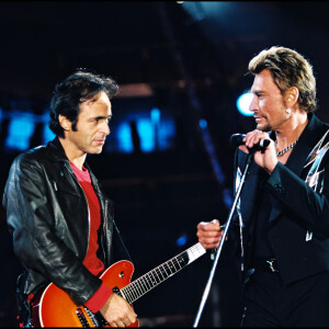 Archives - Jean-Jacques Goldman et Johnny Hallyday sur scène lors d'un concert au Stade de France.