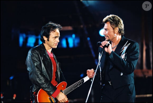 Archives - Jean-Jacques Goldman et Johnny Hallyday sur scène lors d'un concert au Stade de France.