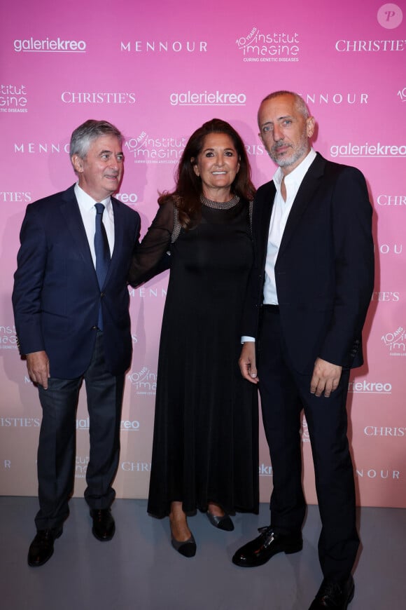 Stanislas Lyonnet, Fati Rosenberg et Gad Elmaleh lors de la soirée de gala "Heroes for Imagine" qui a permis de récolter dix millions d'euros au profit de la recherche contre les maladies génétiques à Paris le 23 septembre 2024. Depuis sa création en 2015, ce gala organisé tous les deux ans au coeur de l'Institut, propose à la vente des oeuvres et des moments d'exception uniques pour soutenir les chercheurs et médecins de l'Institut Imagine, qui oeuvrent au quotidien pour comprendre et guérir les maladies génétiques. Cette vente caritative est fondamentale pour l'avenir d'Imagine. Elle permet d'accélérer ses grands projets stratégiques, de conforter son attractivité, et de répondre aux besoins de la recherche en termes d'équipements et de technologies de pointe, comme en recrutement de talents. En quatre éditions, HEROES for Imagine a permis de lever plus de 22 millions d'euros. Et 2024 est une année toute particulière pour l'Institut Imagine qui fête ses 10 ans mais aussi la cinquième édition d'Heroes, actuellement en pleine préparation ! "Grâce à Heroes, la recherche sur les maladies génétiques s'accélère, quels que soient les obstacles, au bénéfice des enfants malades et de leurs familles. Avec virtuosité et engagement, les chercheurs et les médecins de l'Institut Imagine, pratiquent la meilleure science d'aujourd'hui pour inventer la meilleure médecine de demain" © Dominique Jacovides / Bestimage 