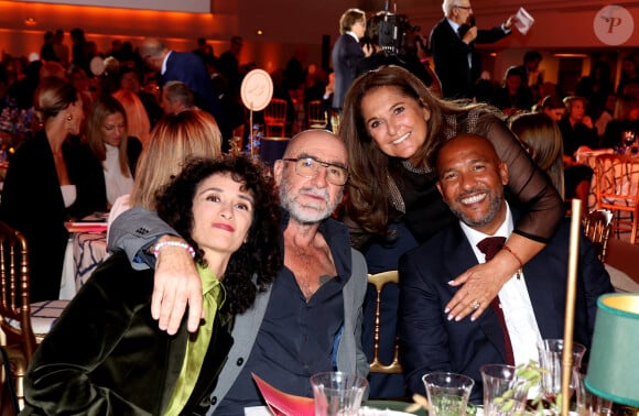 Rachida Brakni, son mari Eric Cantona, Fati Rosenberg, Olivier Dacourt lors de la soirée de gala "Heroes for Imagine" qui a permis de récolter dix millions d'euros au profit de la recherche contre les maladies génétiques à Paris le 23 septembre 2024. Depuis sa création en 2015, ce gala organisé tous les deux ans au coeur de l'Institut, propose à la vente des oeuvres et des moments d'exception uniques pour soutenir les chercheurs et médecins de l'Institut Imagine, qui oeuvrent au quotidien pour comprendre et guérir les maladies génétiques. Cette vente caritative est fondamentale pour l'avenir d'Imagine. Elle permet d'accélérer ses grands projets stratégiques, de conforter son attractivité, et de répondre aux besoins de la recherche en termes d'équipements et de technologies de pointe, comme en recrutement de talents. En quatre éditions, HEROES for Imagine a permis de lever plus de 22 millions d'euros. Et 2024 est une année toute particulière pour l'Institut Imagine qui fête ses 10 ans mais aussi la cinquième édition d'Heroes, actuellement en pleine préparation ! "Grâce à Heroes, la recherche sur les maladies génétiques s'accélère, quels que soient les obstacles, au bénéfice des enfants malades et de leurs familles. Avec virtuosité et engagement, les chercheurs et les médecins de l'Institut Imagine, pratiquent la meilleure science d'aujourd'hui pour inventer la meilleure médecine de demain" © Dominique Jacovides / Bestimage 