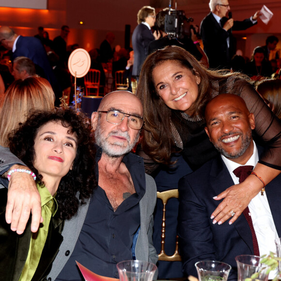 Rachida Brakni, son mari Eric Cantona, Fati Rosenberg, Olivier Dacourt lors de la soirée de gala "Heroes for Imagine" qui a permis de récolter dix millions d'euros au profit de la recherche contre les maladies génétiques à Paris le 23 septembre 2024. Depuis sa création en 2015, ce gala organisé tous les deux ans au coeur de l'Institut, propose à la vente des oeuvres et des moments d'exception uniques pour soutenir les chercheurs et médecins de l'Institut Imagine, qui oeuvrent au quotidien pour comprendre et guérir les maladies génétiques. Cette vente caritative est fondamentale pour l'avenir d'Imagine. Elle permet d'accélérer ses grands projets stratégiques, de conforter son attractivité, et de répondre aux besoins de la recherche en termes d'équipements et de technologies de pointe, comme en recrutement de talents. En quatre éditions, HEROES for Imagine a permis de lever plus de 22 millions d'euros. Et 2024 est une année toute particulière pour l'Institut Imagine qui fête ses 10 ans mais aussi la cinquième édition d'Heroes, actuellement en pleine préparation ! "Grâce à Heroes, la recherche sur les maladies génétiques s'accélère, quels que soient les obstacles, au bénéfice des enfants malades et de leurs familles. Avec virtuosité et engagement, les chercheurs et les médecins de l'Institut Imagine, pratiquent la meilleure science d'aujourd'hui pour inventer la meilleure médecine de demain" © Dominique Jacovides / Bestimage 