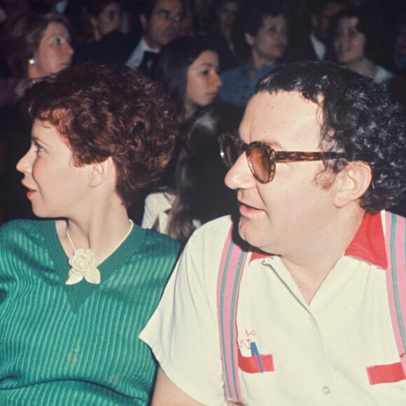 Notamment le fait de se rendre régulièrement dans leur maison de vacances 
Archives - Rufus, Coluche et sa femme Véronique Colucci au Festival de Cannes. Mai 1976.