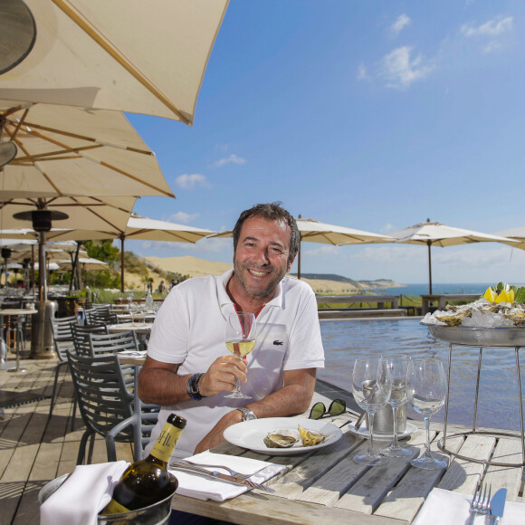 Bernard Montiel, présentateur et animateur radio pose sur la terrasse du restaurant "La Corniche" en dégustant un verre de vin blanc du château Smith Au Lafitte et quelques huïtres.  © Thibaud Moritz / Bestimage