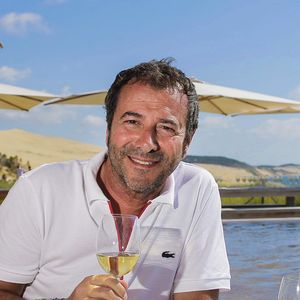 S'il l'a vendue depuis plusieurs années, il ya désormais de nouveaux propriétaires 
Bernard Montiel, présentateur et animateur radio pose sur la terrasse du restaurant "La Corniche" en dégustant un verre de vin blanc du château Smith Au Lafitte et quelques huïtres.© Thibaud Moritz / Bestimage