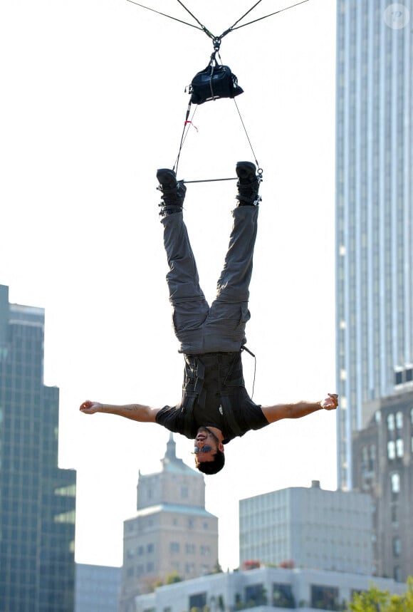 Magicien, prestidigitateur, David Blaine a ébloui le monde avec ses exploits...Le magicien et "homme à l'envers" David Blaine est soulevé à 44 pieds au-dessus de la patinoire Wollman de Central Park à New York City, NY, USA, le 22 septembre 2008, pour commencer son dernier défi d'endurance, "David Blaine : Le plongeon de la mort". Blaine sera suspendu sans filet pendant 60 heures, pour terminer par un plongeon à couper le souffle. Photo par S.Vlasic/ABACAPRESS.COM