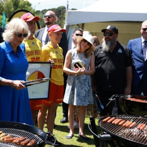 Le couple a pris beaucoup de plaisir à faire cuire lui-même ses saucisses. 
Le roi Charles III d'Angleterre et Camilla Parker Bowles, reine consort d'Angleterre, participent au barbecue communautaire à Sydney, le 22 octobre 2024.