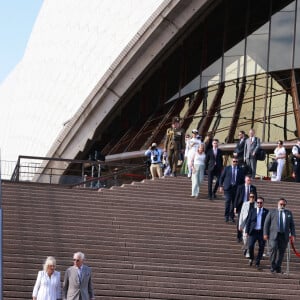 Le roi Charles III d'Angleterre et Camilla Parker Bowles, reine consort d'Angleterre, descendent l'escalier de l'opéra de Sydney lors de leur visite officielle en Australie, le 22 octobre 2024. 