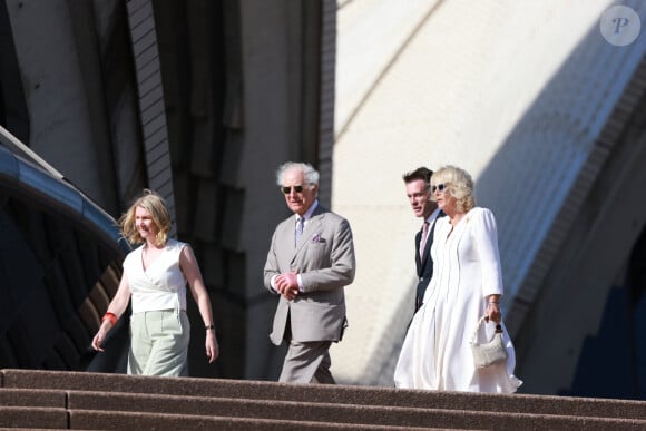 Le roi Charles III d'Angleterre et Camilla Parker Bowles, reine consort d'Angleterre, descendent l'escalier de l'opéra de Sydney lors de leur visite officielle en Australie, le 22 octobre 2024. 