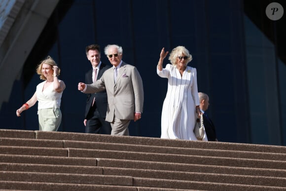 Le roi Charles III d'Angleterre et Camilla Parker Bowles, reine consort d'Angleterre, descendent l'escalier de l'opéra de Sydney lors de leur visite officielle en Australie, le 22 octobre 2024. 