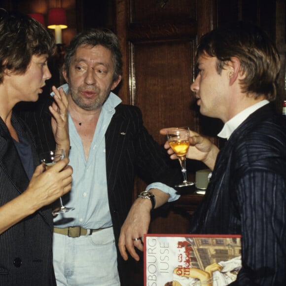 Archives - No Web - En France, à Paris, lors du cocktail pour la sortie de la bande dessinée OU ES-TU MELODY ? de IUSSE, inspiré par des chansons de Serge GAINSBOURG, IUSSE et Serge GAINSBOURG un verre à la main, avec Jane BIRKIN. Septembre 1987 © Bernard Leguay via Bestimage