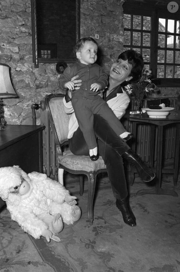 Archive - En France, à Ballainvilliers, Maria Pacôme chez elle, dans sa maison, tenant son fils François-Pierre agé de 18 mois le 5 décembre 1966