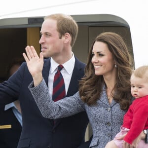 Le prince William, Catherine Kate Middleton la duchesse de Cambridge et leur fils George montent à bord d'un avion pour rentrer à Londres après leur visite officielle en Australie, le 25 avril 2014.