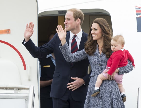 Le prince William, Catherine Kate Middleton la duchesse de Cambridge et leur fils George montent à bord d'un avion pour rentrer à Londres après leur visite officielle en Australie, le 25 avril 2014.