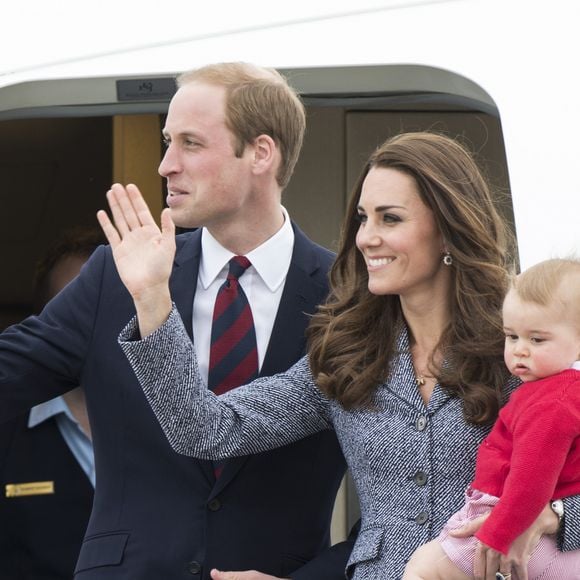 Le prince William, Catherine Kate Middleton la duchesse de Cambridge et leur fils George montent à bord d'un avion pour rentrer à Londres après leur visite officielle en Australie, le 25 avril 2014.