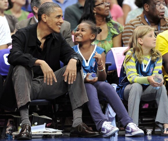 Barack Obama assiste à un match de basket féminin, le 1er août 2010. Sa fille Sasha est à ses côtés. 