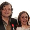 Emir Kusturica prend la pose aux côtés de son épouse Maja après avoir été fait Chevalier dans l'Ordre de la Légion d'Honneur par le ministre de la culture Frédéric Mitterrand au Café des Palmes dans le Palais des Festivals lors du 64e Festival de Cannes le 13 mai 2011