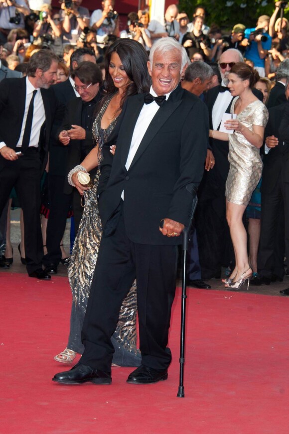Jean-Paul Belmondo remonte les marches du palais des festivals, lors du 64e festival de Cannes, à l'occasion de la projection du documentaire "Belmondo, itinéraire..." La sulfureuse Barbara Gandolfi est à ses côtés ! Le 17 mai 2011