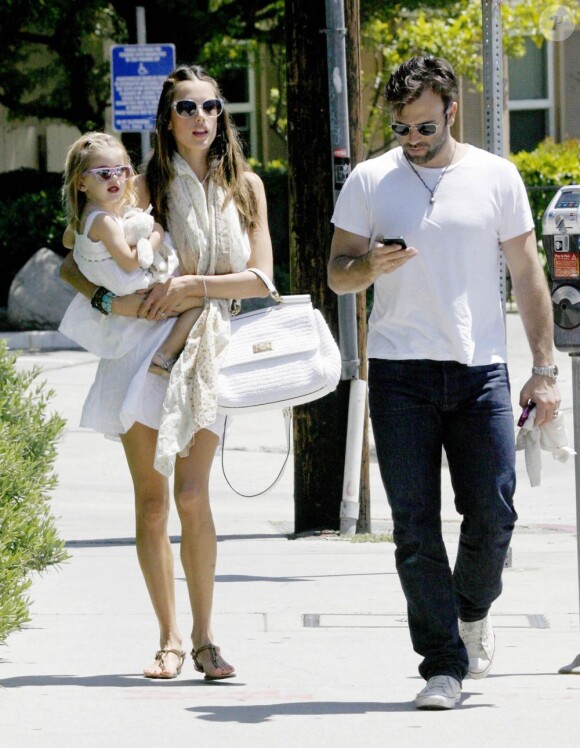 Pendant qu'Alessandra Ambrosio porte leur fille Anja, Jamie Mazur consulte son téléphone, à Los Angeles le 27 mai 2011.