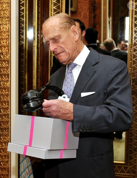 Le duc d'Edimbourg, le prince Philip reçoit une paire de protège-oreilles comme cadeau d'anniversaire de la part de Jackie Ballard, la directrice de l'association contre la perte d'audition durant une soirée caritative au Buckingham Palace pour l'anniversaire du duc d'Edimbourg qui célèbre ses 90 ans le 12 juin 2011
