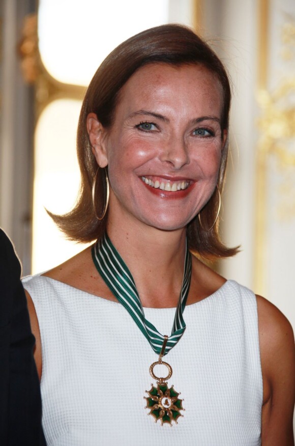 Carole Bouquet, souriante, radieuse et décorée de la médaille de Commandeur de l'ordre des Arts et des Lettres le 23 septembre 2011 à Paris