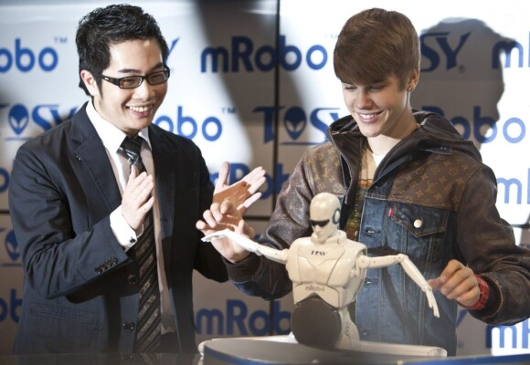 Délirant, Justin Bieber découvre un prototype de robot qui danse, lors du salon CES le 11 janvier 2012 à Las Vegas