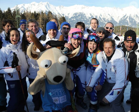 Clara Direz (à d.) et Estelle Alphand (à g., casque rose) posent avec la mascotte Yoggi et la délégation française après leur doublé or-argent dans le slalom géant aux Jeux Olympiques d'Hiver de la Jeunesse d'Innsbruck, le 18 janvier 2012.