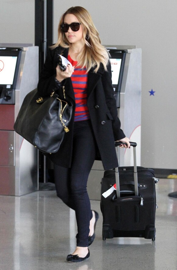 Lauren Conrad à l'aéroport de Los Angeles, s'envole avec style, habillée d'un sweat rayé Enza Costa sur un total look noir. Le 2 février 2012.