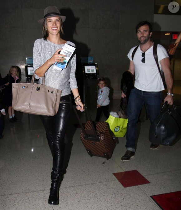 Alessandra Ambrosio a le sourire à l'aéroport de Los Angeles, accompagnée par sa petite famille. Le 3 février 2012.