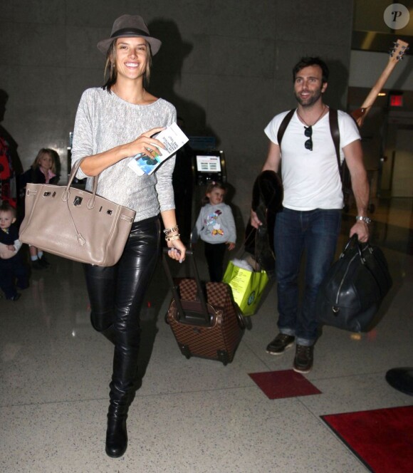 Alessandra Ambrosio, souriante avec sa petite famille à l'aéroport de Los Angeles, le 3 février 2012.