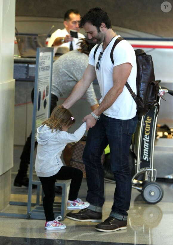 Alessandra Ambrosio s'occupe des valises pendant que Jamie Mazur s'amuse avec leur fille. Los Angeles, le 3 février 2012.