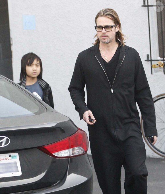 Brad Pitt en combinaison et son fils Maddox à la sortie d'un magasin de guitares, à Los Angeles, le 1er mars 2012.