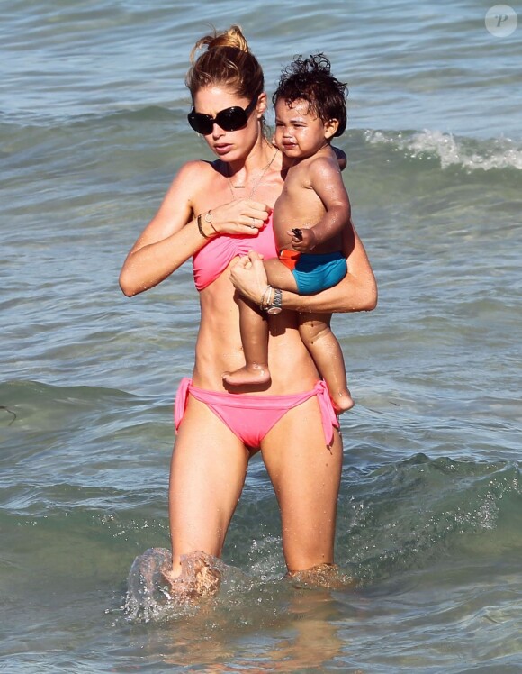 Doutzen Kroes batifole avec son fils Phyllon sur une plage à Miami. Le 24 mars 2012.