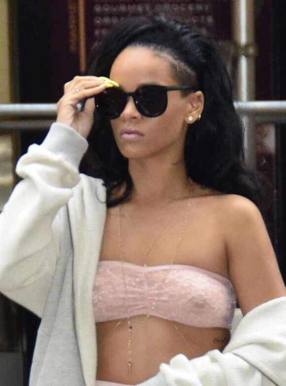 Rihanna, sans soutien-gorge, laisse sa poitrine apparente sous un bandeau American Apparel. New York, le 11 juin 2012.