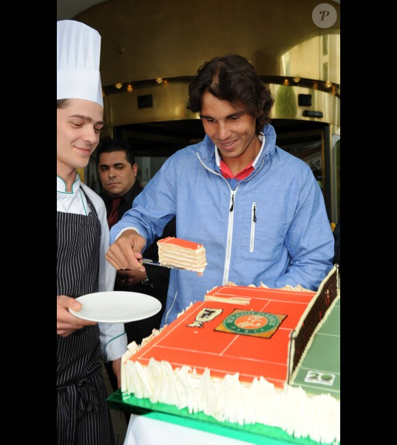 Rafael Nadal à Halle en Allemagne, découpe un gâteau célébrant sa septième victoire à Roland-Garros le 12 juin 2012