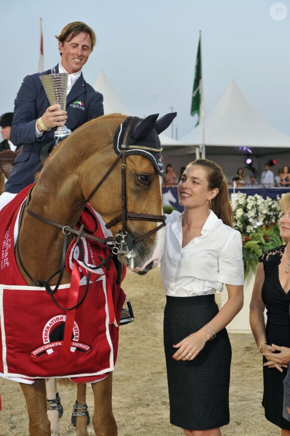 Charlotte Casiraghi, entourée du joaillier Yves Piaget et de la présidente de la Fédération monégasque d'équitation, a remis au cavalier britannique Ben Maher et à son cheval Aristo leur récompense pour leur victoire dans le Prix Fédération Equestre de Monaco, le 28juin 2012.