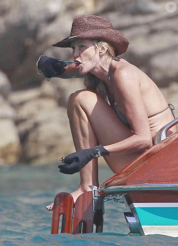 Elle Macpherson goûte ses oursins fraîchement pêchés durant une balade en bateau. Ibiza, le 11 juillet 2012.