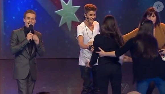 Le présentateur d'Australia's Got Talent et Justin Bieber gardent le sourire alors que la jeune fan est tirée par les assistants.