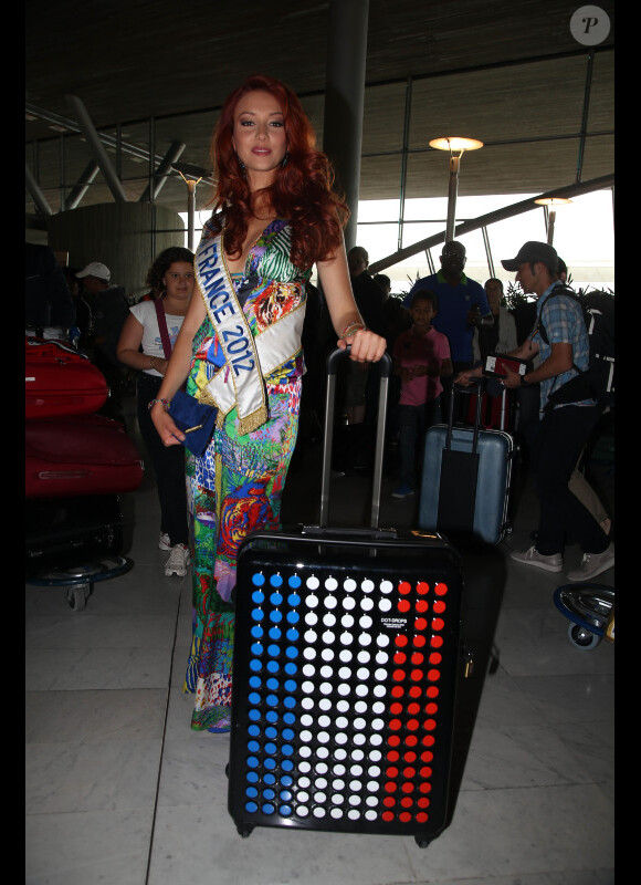 Delphine Wespiser arbore une valise très frenchy lors de son départ pour le concours de Miss Monde en Chine le 19 juillet 2012 à l'aéroport Roissy Charles de Gaulle