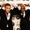 Robbie Williams, Icône de l'Année des GQ Men Of The Year Awards 2012, fait le Mobot avec l'athlète Mo Farah. Londres, le 4 septembre 2012.