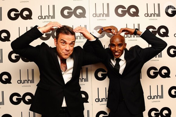 Robbie Williams, Icône de l'Année des GQ Men Of The Year Awards 2012, fait le Mobot avec l'athlète Mo Farah. Londres, le 4 septembre 2012.