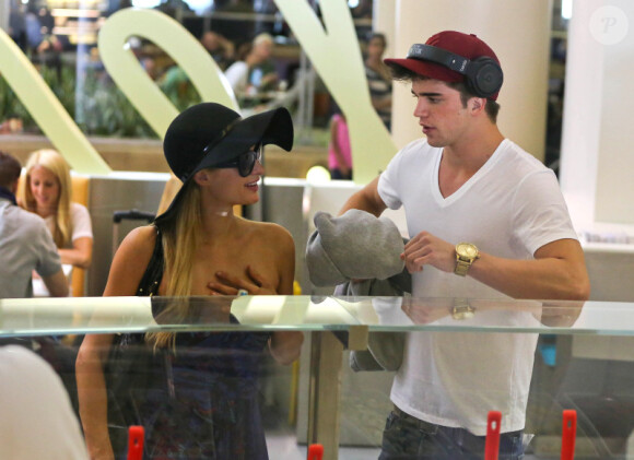 Paris Hilton, tout sourire, à l'aéroport LAX de Los Angeles, en compagnie de son boyfriend, le vendredi 21 septembre 2012.